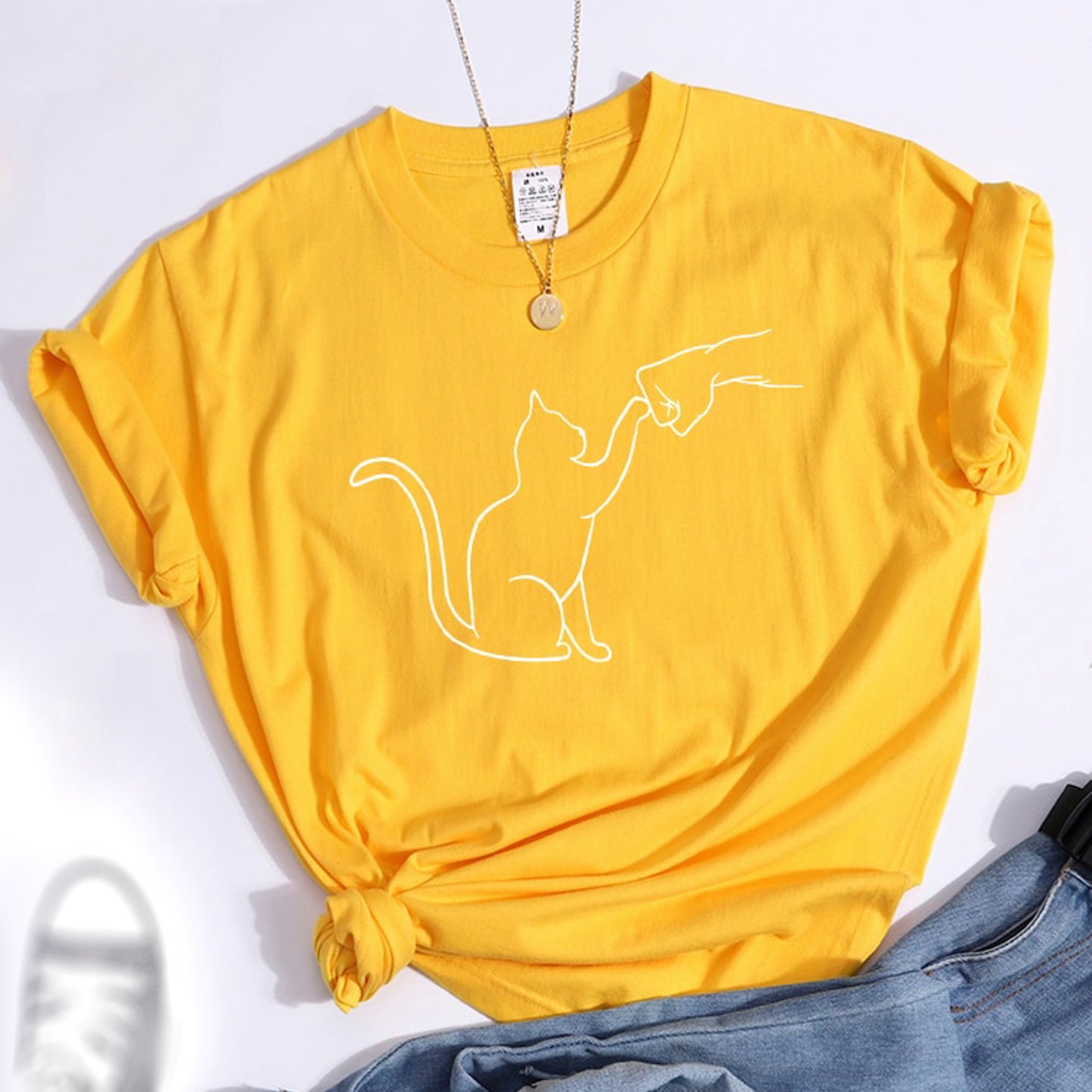 グータッチする猫のイラストがプリントされたTシャツのイエロー