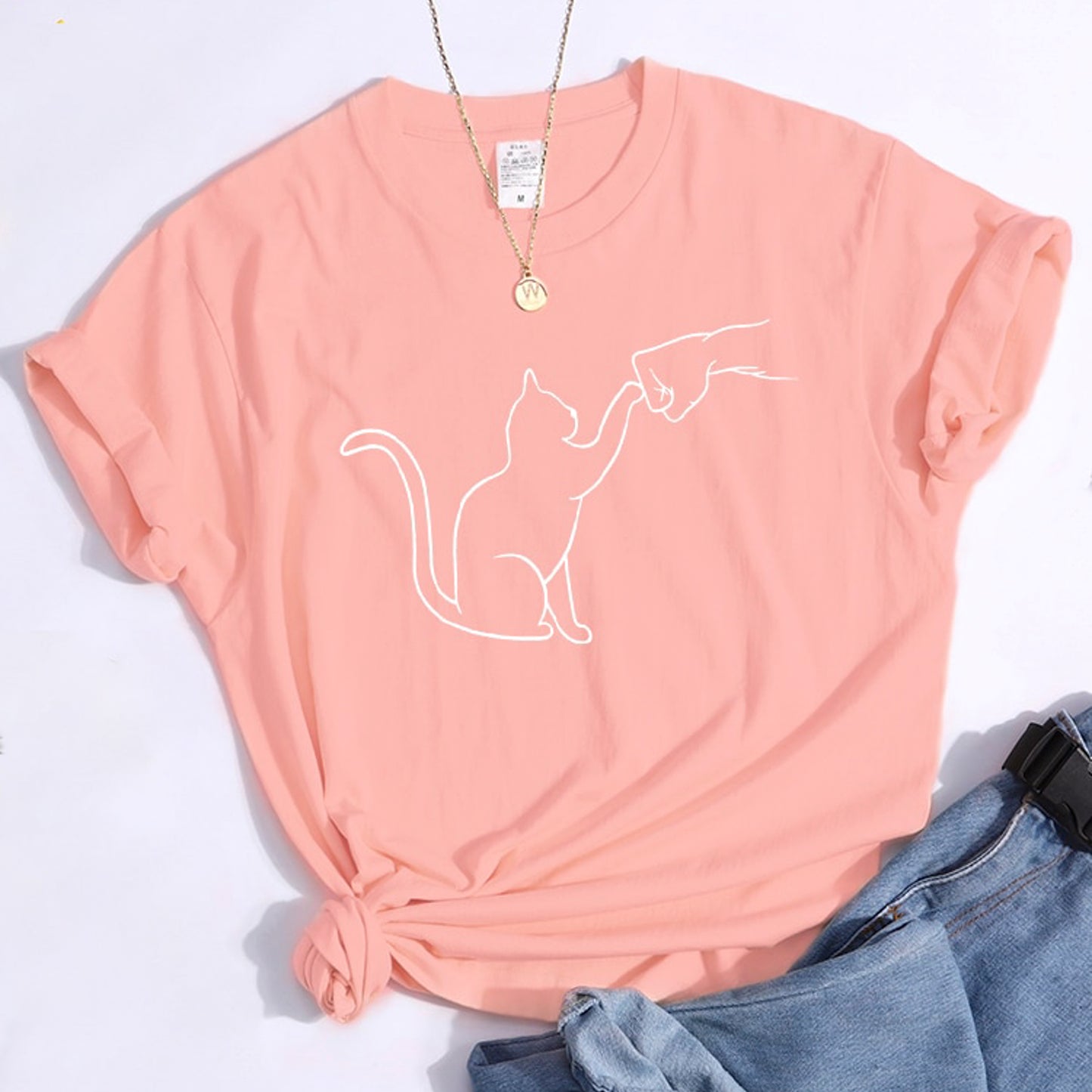 グータッチする猫のイラストがプリントされたTシャツのピンク