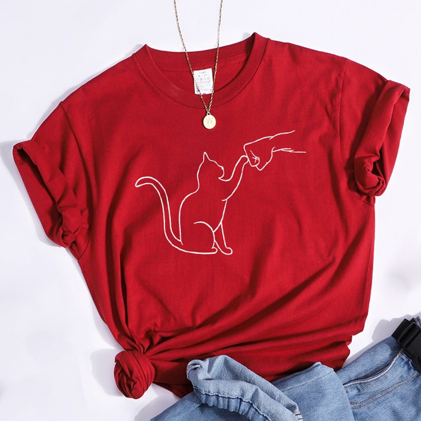 グータッチする猫のイラストがプリントされたTシャツのレッド