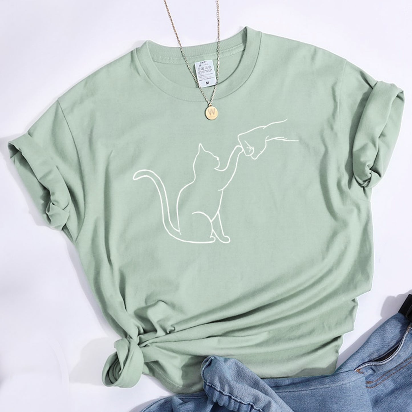 グータッチする猫のイラストがプリントされたTシャツのライトグリーン