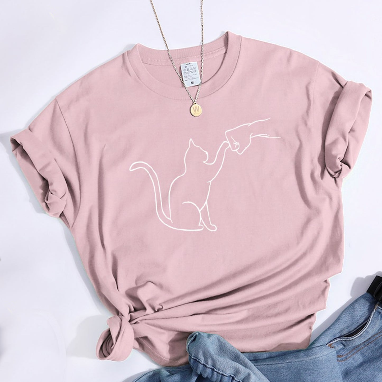 グータッチする猫のイラストがプリントされたTシャツのライトピンク