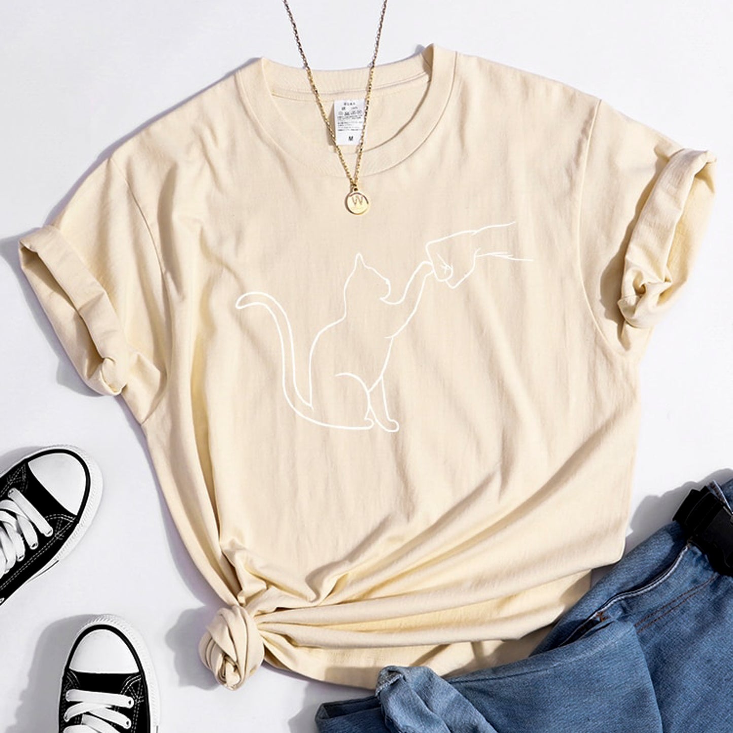 グータッチする猫のイラストがプリントされたTシャツのベージュ