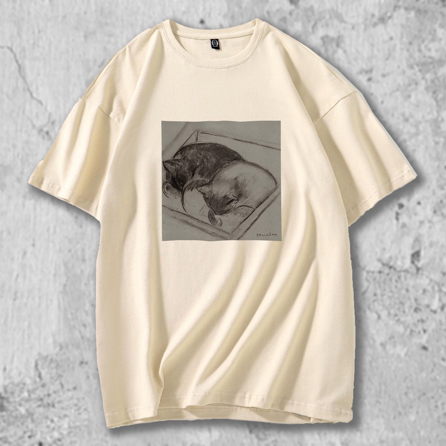 眠る猫のイラストがプリントされたTシャツのベージュ