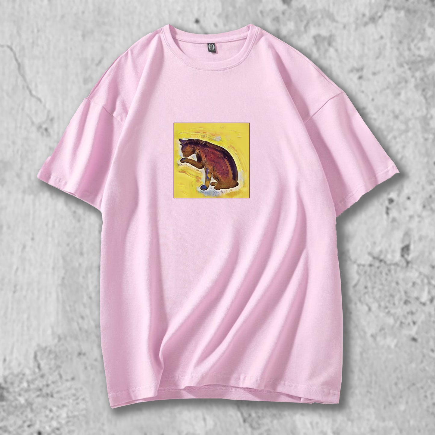 手を舐める猫のイラストがプリントされたTシャツのピンク