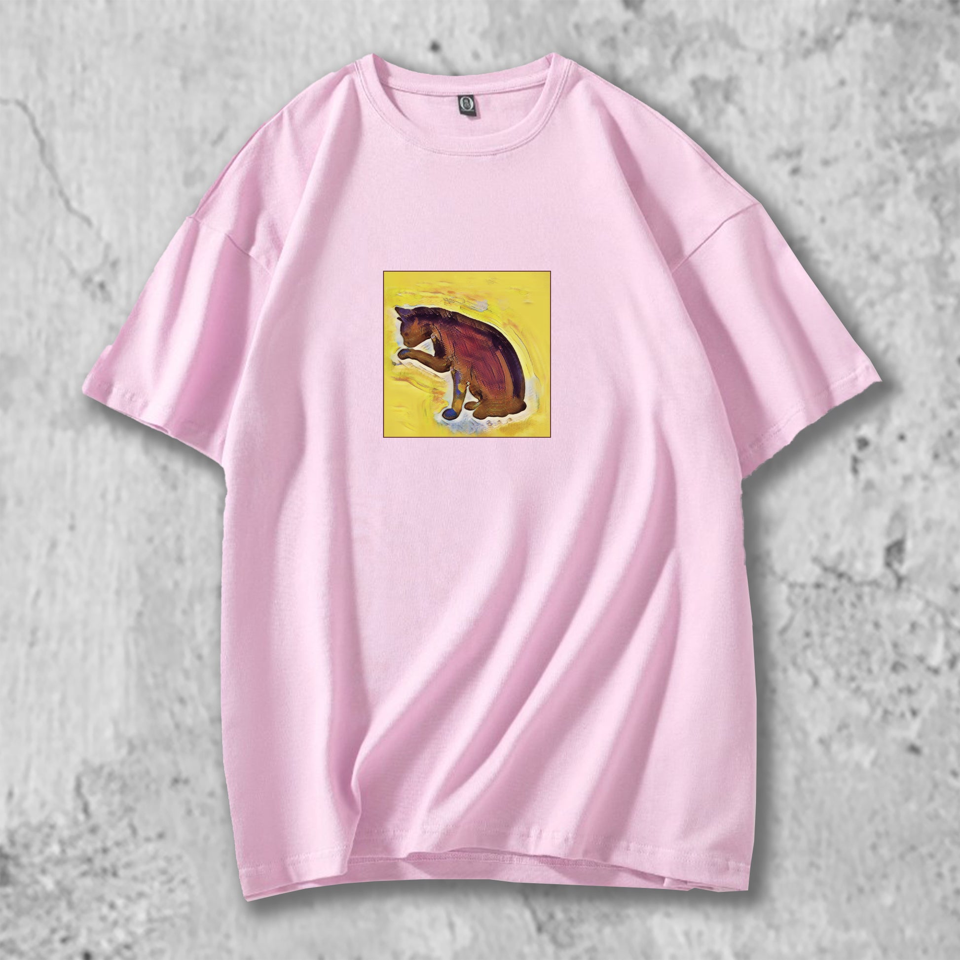 手を舐める猫のイラストがプリントされたTシャツのピンク