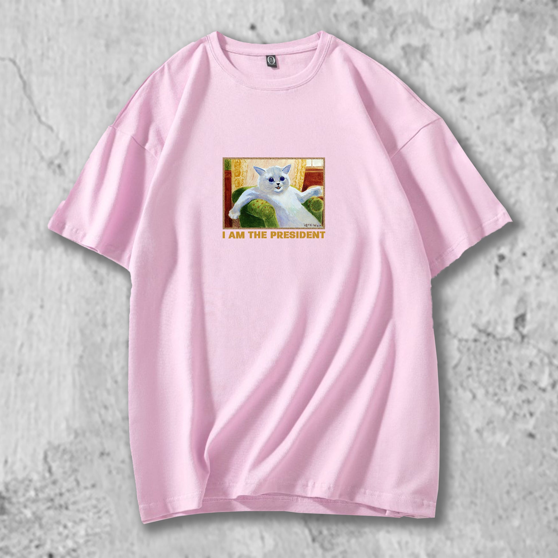 白猫のイラストがプリントされたTシャツのピンク